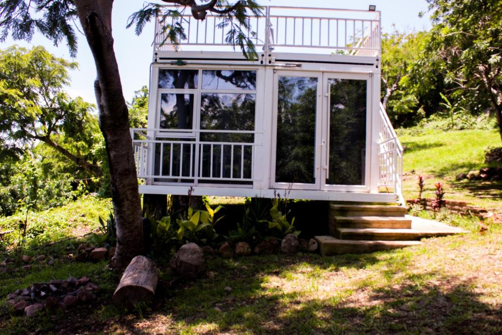 une cabane dans les arbres avec une terrasse couverte et des escaliers dans l'établissement Serenity Mezcala - Abitare, 