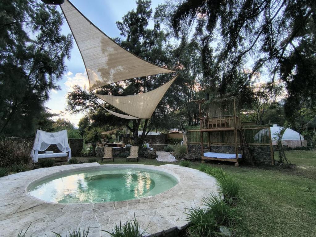 a hammock hanging over a small pool in a yard at Paraje Real Malinalco in San Martín