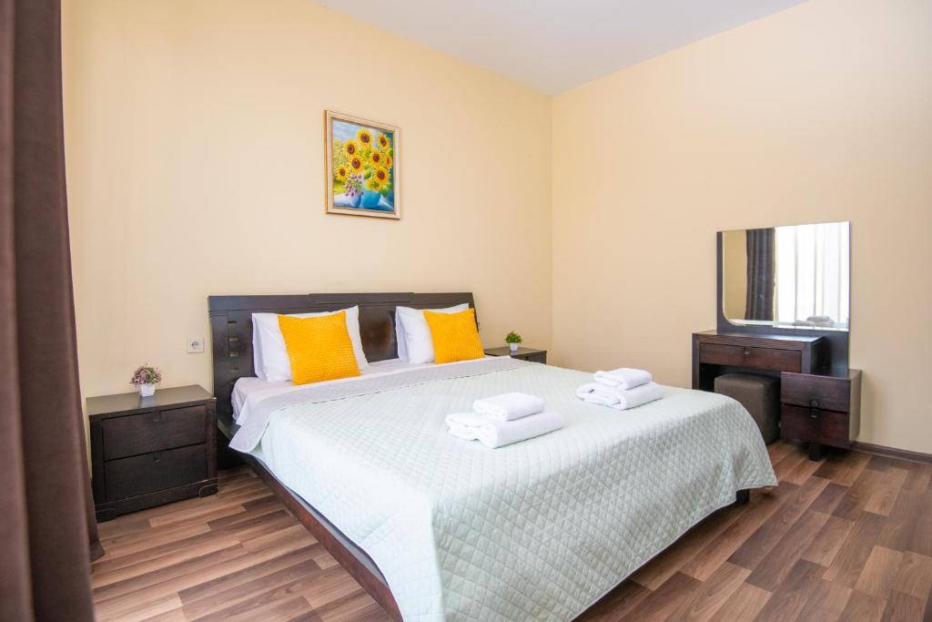 a bedroom with a large bed with towels on it at Cozy stay rentals- cozy & sweet 1 BR apartment in Tbilisi with city & mountains view in Tbilisi City