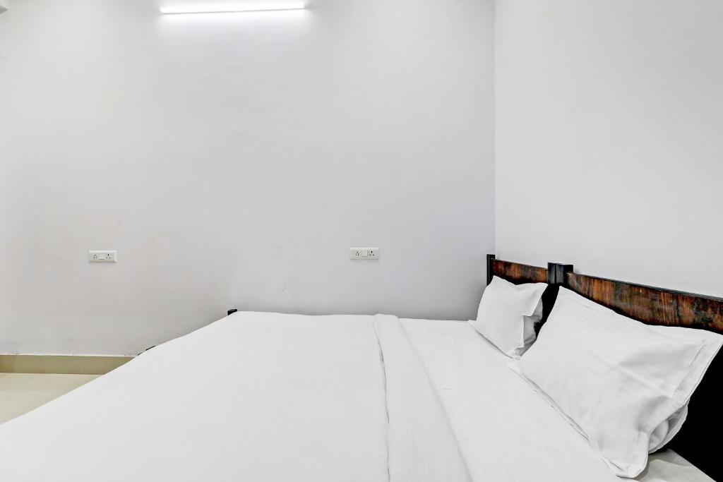 a white bed with white sheets and pillows at Hotel O The Lemongrass in Colonelganj