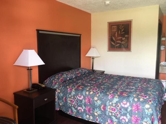 a hotel room with a bed and two lamps in it at Regency Inn and Suites Bay City, Texas in Bay City