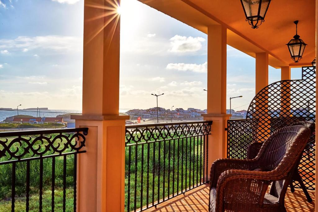 - une terrasse couverte avec des chaises et une vue sur l'océan dans l'établissement Silver Coast Beach Residence, à Baleal