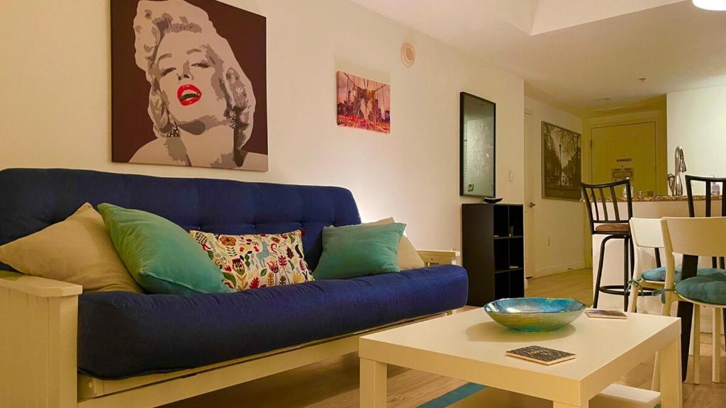 Una sala de estar con un sofá azul y una mesa. en Beautyful Apartment, Boynton Beach, Casa Costa, FL, en Boynton Beach