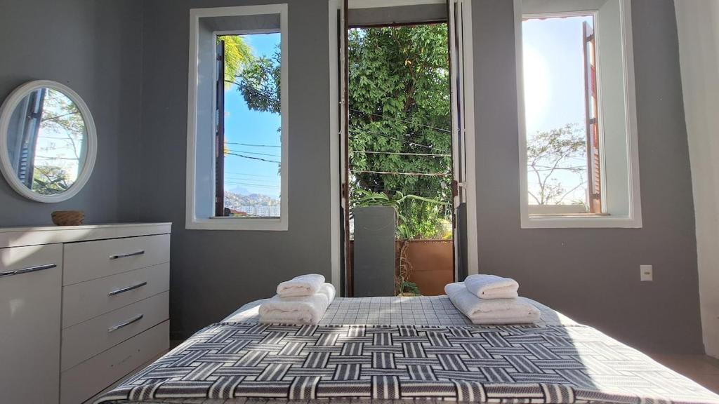 ein Schlafzimmer mit einem Bett mit zwei Handtüchern darauf in der Unterkunft Casa com mini floresta, a paz ao lado do Centro in Rio de Janeiro