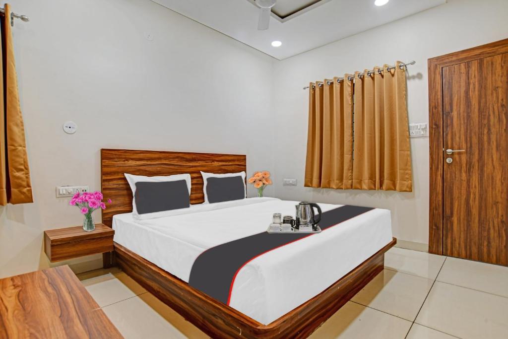 a bedroom with a large bed with a wooden headboard at FabHotel Adiyogi Aura in Indore