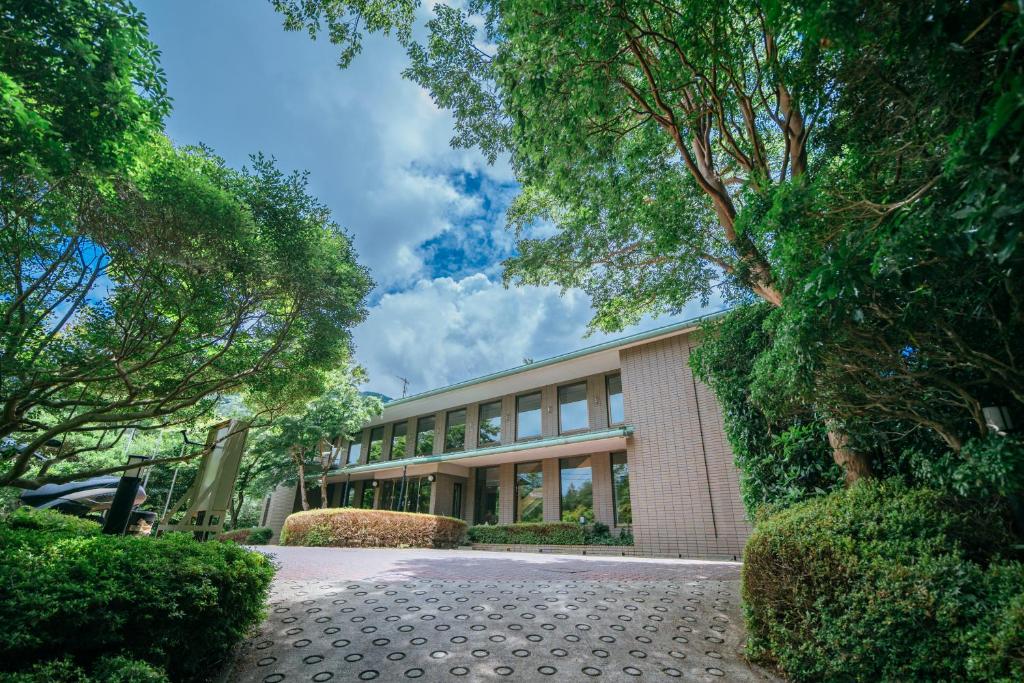 箱根Sengokuhara Onsen Hotel的前面有树木的大建筑