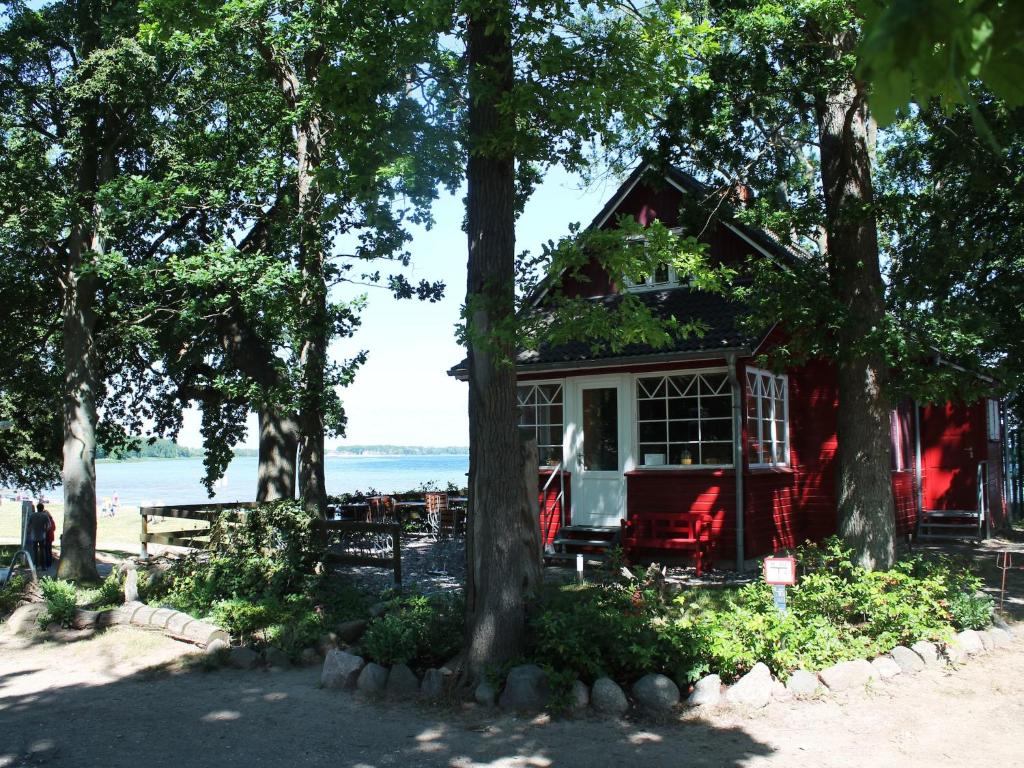 a red house with red chairs and trees at Ferienhaus in Zierow in Zierow
