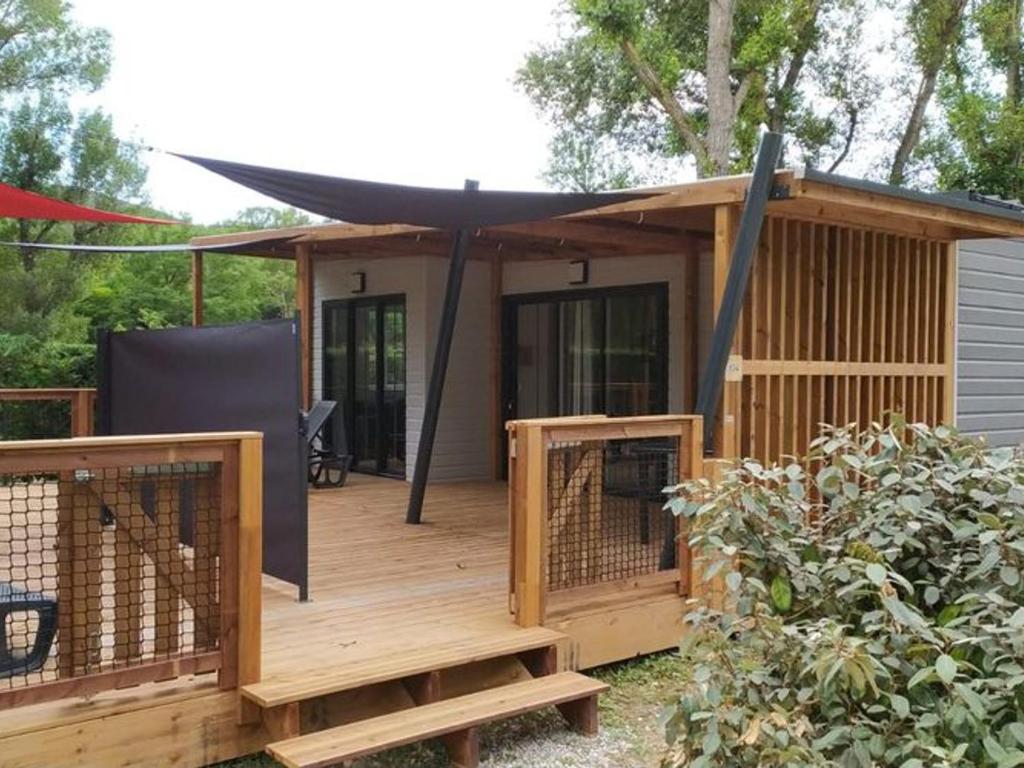 una casa con terraza con toldo negro en Chalet spacieux avec terrasse pour 6 personnes - API-1-52-482, en Saint-Maime