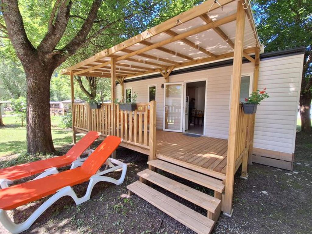 a wooden deck with a pergola and two chairs at Mobil-home 3 chambres avec terrasse à Valbonnais - API-1-52-473 in Valbonnais