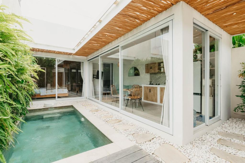 ein Hallenbad in einem Haus mit Glasschiebetüren in der Unterkunft Namera Hidden Moon - 1 BR Brand New Villa in Kerobokan