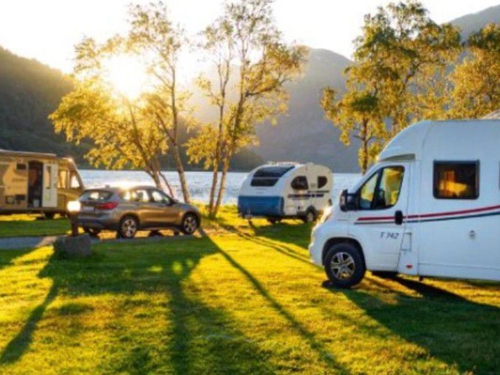 a group of vehicles parked in a field next to a lake at Mobil-home à Esparron-de-Verdon - 2 chambres, terrasse - API-1-52-578 in Esparron-de-Verdon