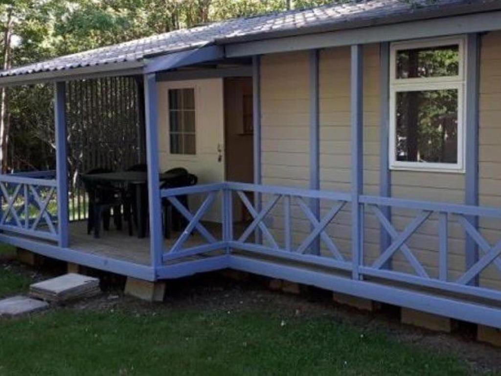 a house with a blue deck with a table on it at Chalet 3 chambres avec terrasse pour 5 personnes - API-1-52-617 in Rives