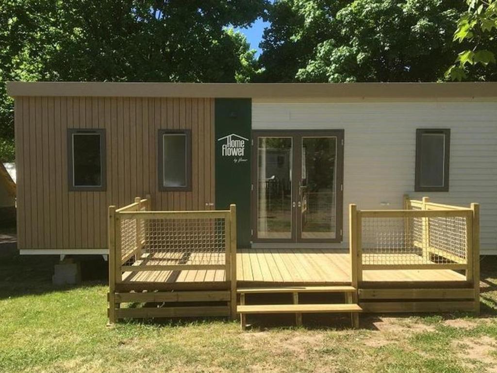 a tiny house with two wooden decks in the grass at Mobil-home pour 6 avec terrasse à Avrillé - API-1-52-728 in Avrillé