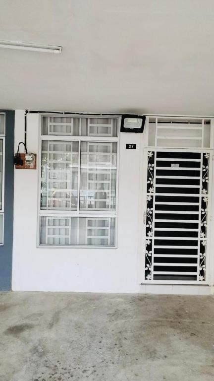 a garage with two windows and a white wall at ZuLee Homestay in Lunas