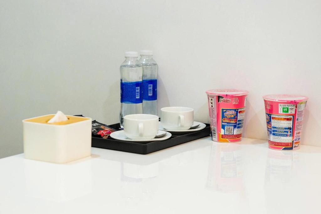 a tray with two drinks and two cups and two soda cans at Hoàng Anh Apartment in Da Nang