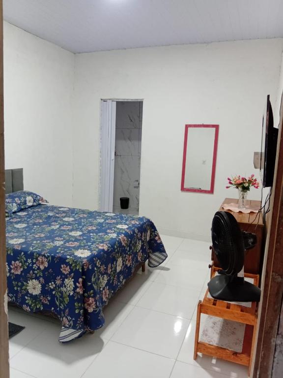 a bedroom with a bed and a chair and a mirror at Casa em salinas in Salinópolis