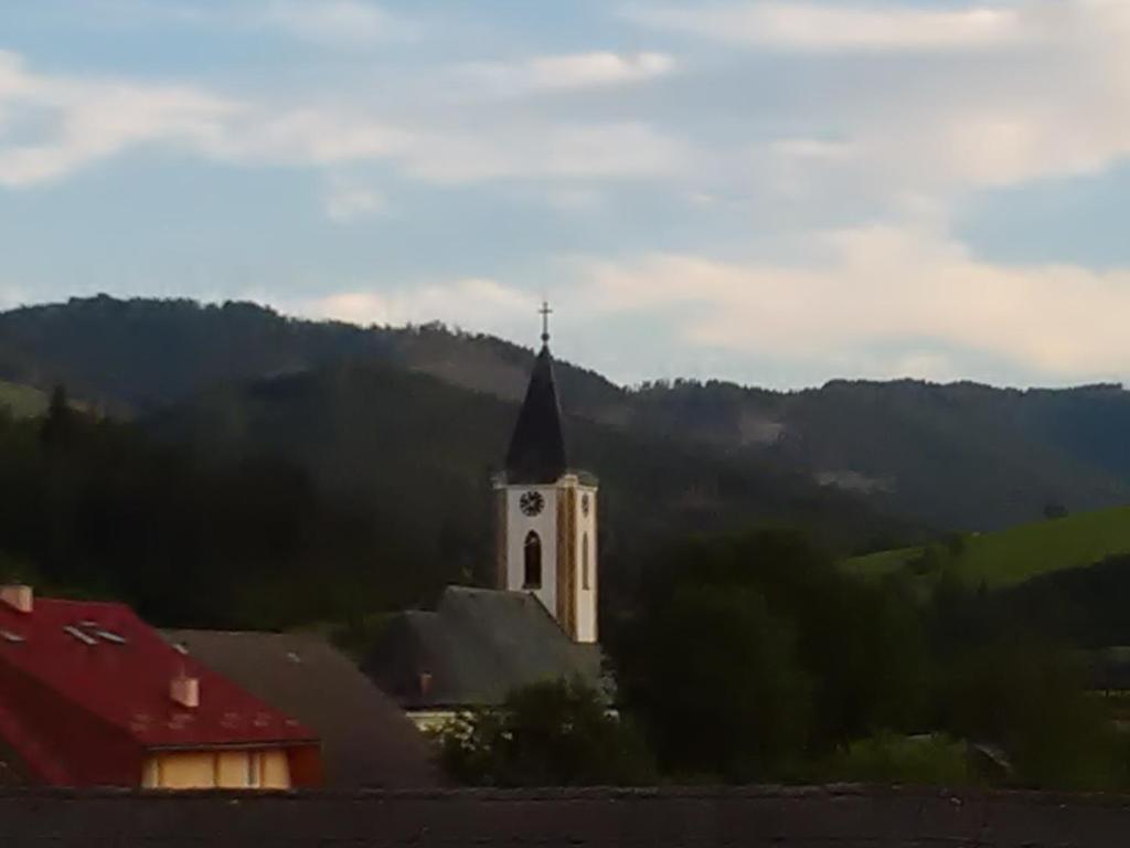 a church with a tower with a clock on it at Apartmány Grobarčík in Zuberec