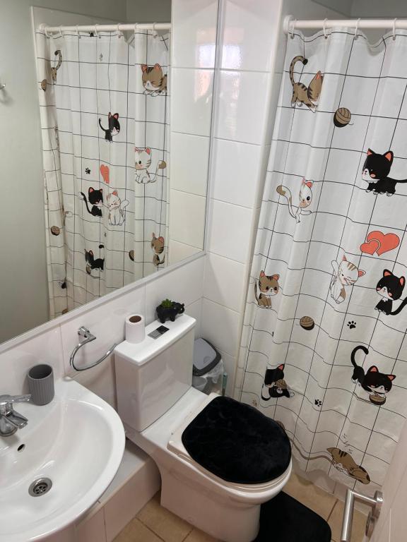 a bathroom with a toilet and a sink at Condominio nuevo lantaño in Chillán