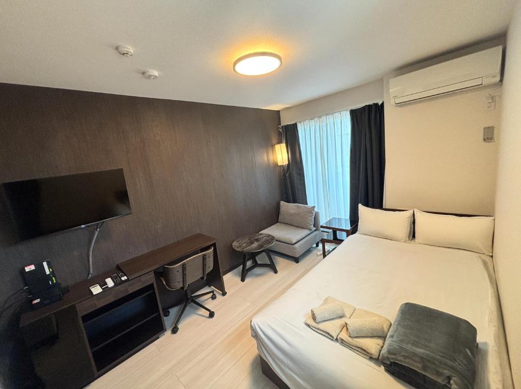 una camera d'albergo con un letto e una televisione di アンドステイ竹ノ塚201 a Tokyo