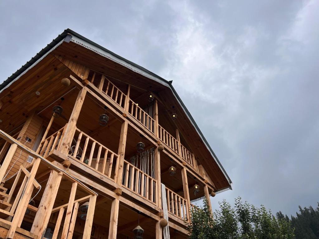 a large wooden building with a sky in the background at The Hidden Cabins in Jibhi