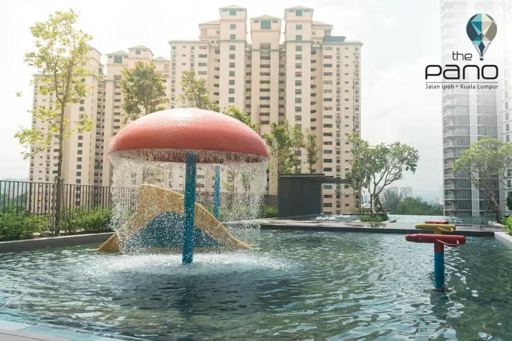 a fountain with an umbrella in the middle of the water at Netflix - City View Pano Studio with Skypool, Free parking and 5 mins to MRT in Kuala Lumpur