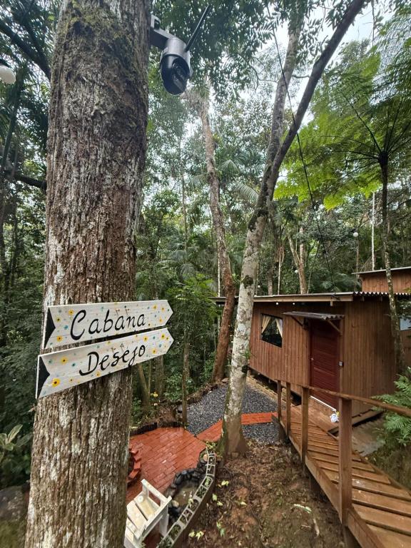 ガスパールにあるCabana Desejoの森の中の小屋の隣の木に立てられた看板