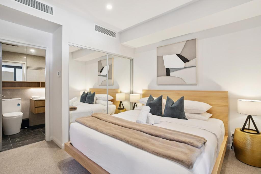 a bedroom with two beds and a bathroom at Luxury 2 Bedroom 2 Bathroom Apartment Walk to Burswood Casino in Perth