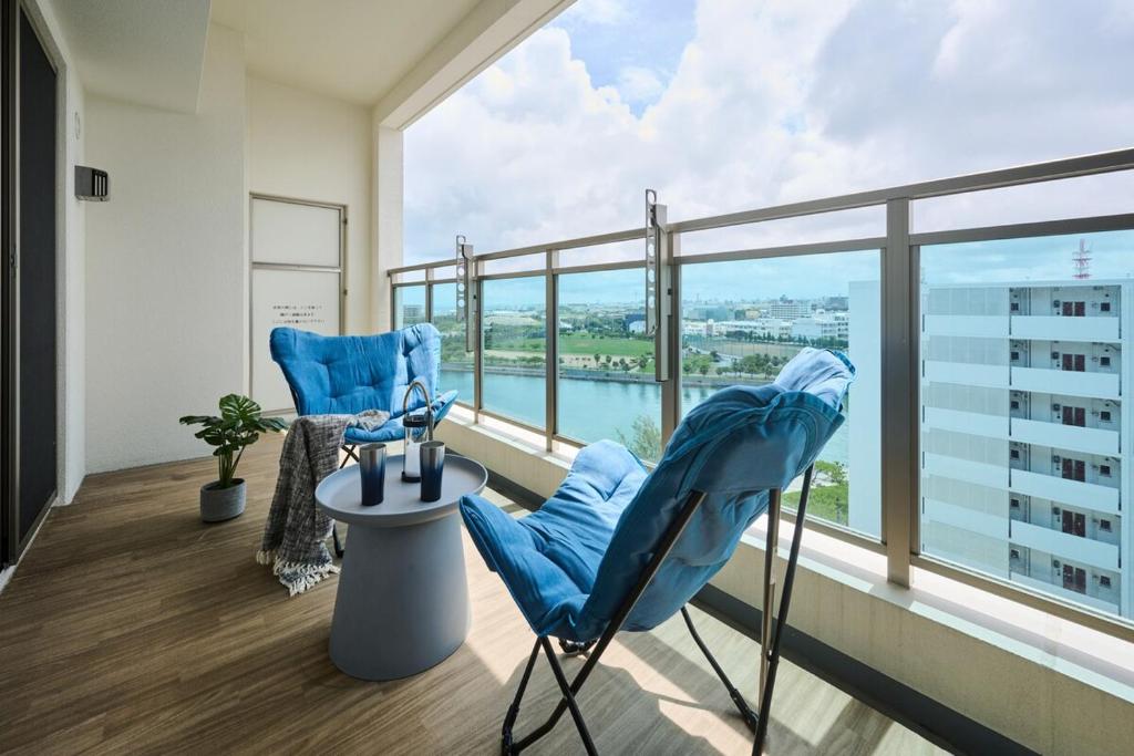 a room with two blue chairs and a large window at Casa YONNA Naha in Naha