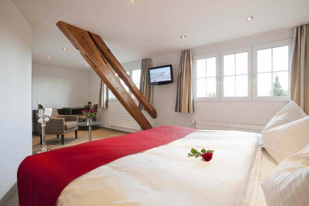 ein Schlafzimmer mit einem Bett mit einer roten Blume darauf in der Unterkunft Landgasthof Wartegg in Wigoltingen