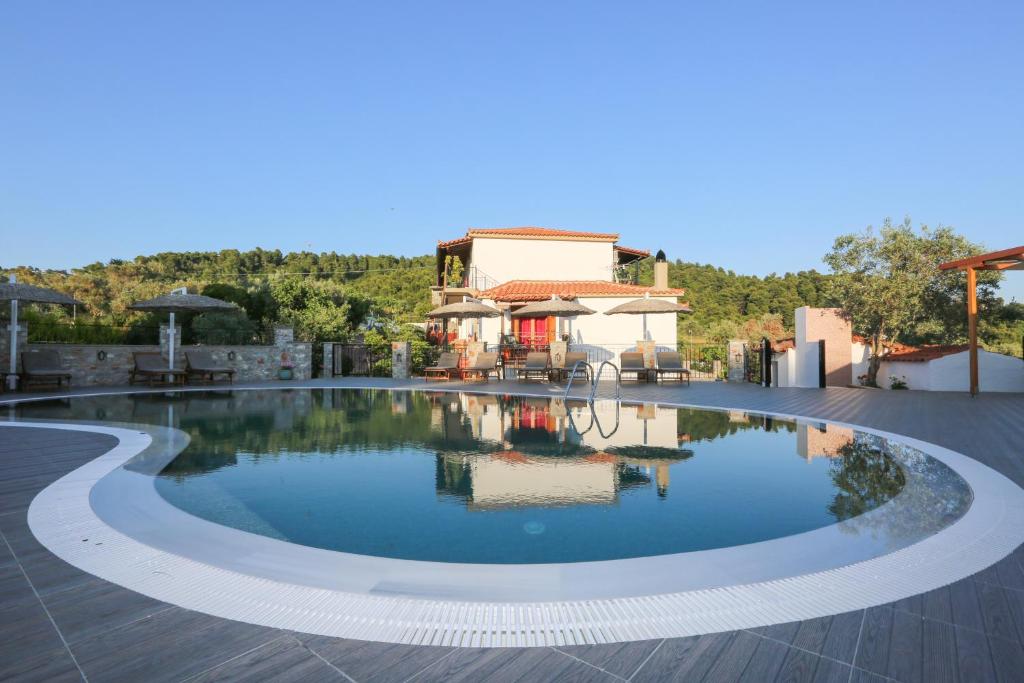 a swimming pool in front of a house at Skiathos Argento in Kolios
