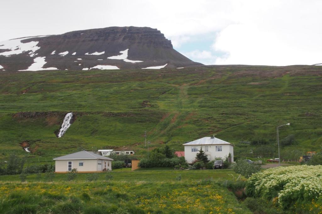 ein Feld mit Häusern und einem Berg im Hintergrund in der Unterkunft Granastaðir Guesthouse in Granastaðir