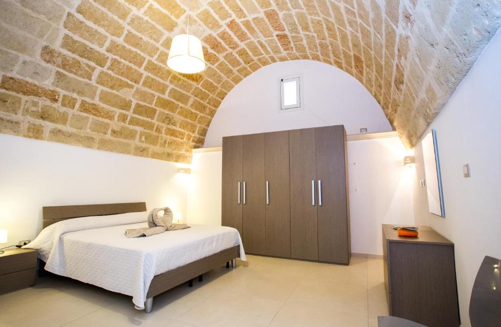 a bedroom with a bed and a brick wall at Da Pippi e Gesuina in Matino
