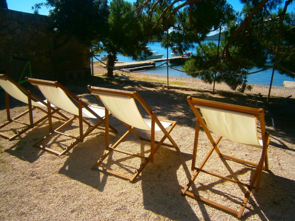 a row of chairs sitting on top of a beach at Bed & Breakfast Pansion Rade in Pirovac