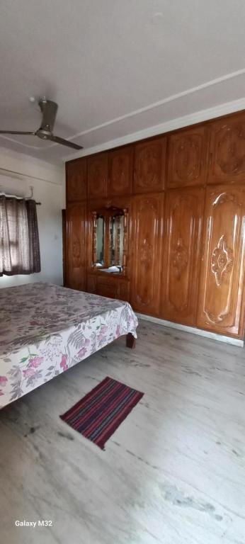 a bedroom with a bed and wooden cabinets and a rug at Cosy Heights Vizag in Visakhapatnam