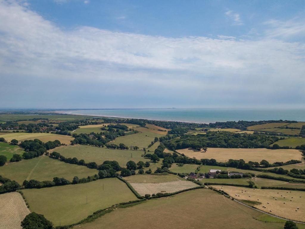 an aerial view of fields and the ocean at Shepherd's Cottage in Pett