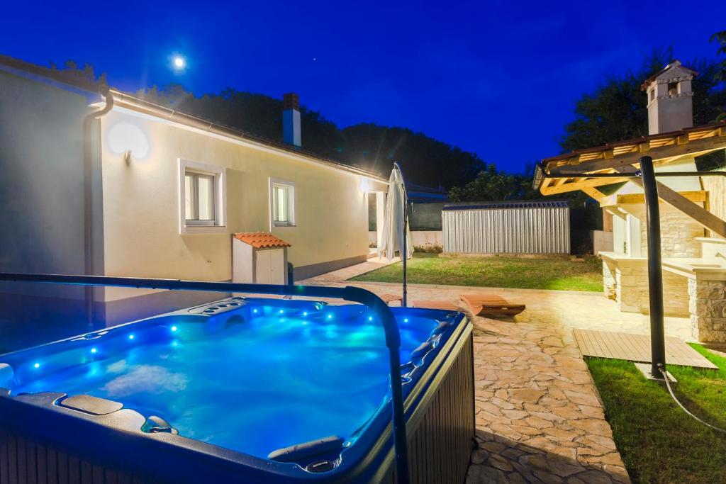 a hot tub in the backyard of a house at night at Holiday Home Freeda in Vintijan