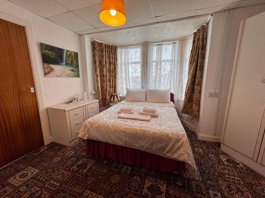 a bedroom with a bed with two towels on it at RideSide Hotel in Blackpool