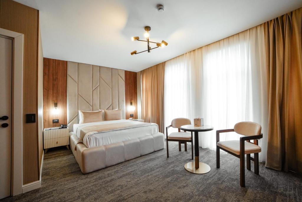 a bedroom with a bed and a table and chairs at White Breeze Hotel in Baku
