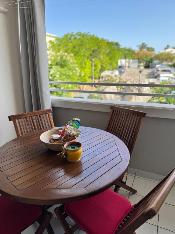 a table with a bowl of food on a balcony at Le Nid du rocher in Le Diamant