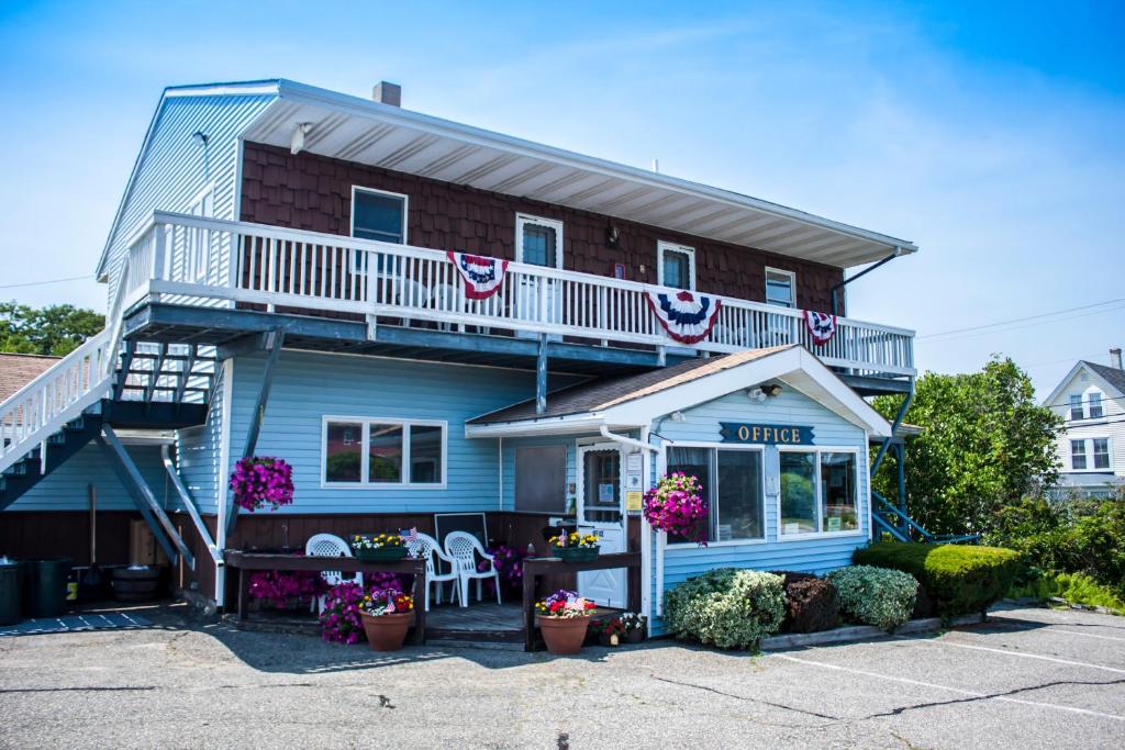 a blue house with a balcony with flowers at Inn Between the Beaches & Villager in York Beach