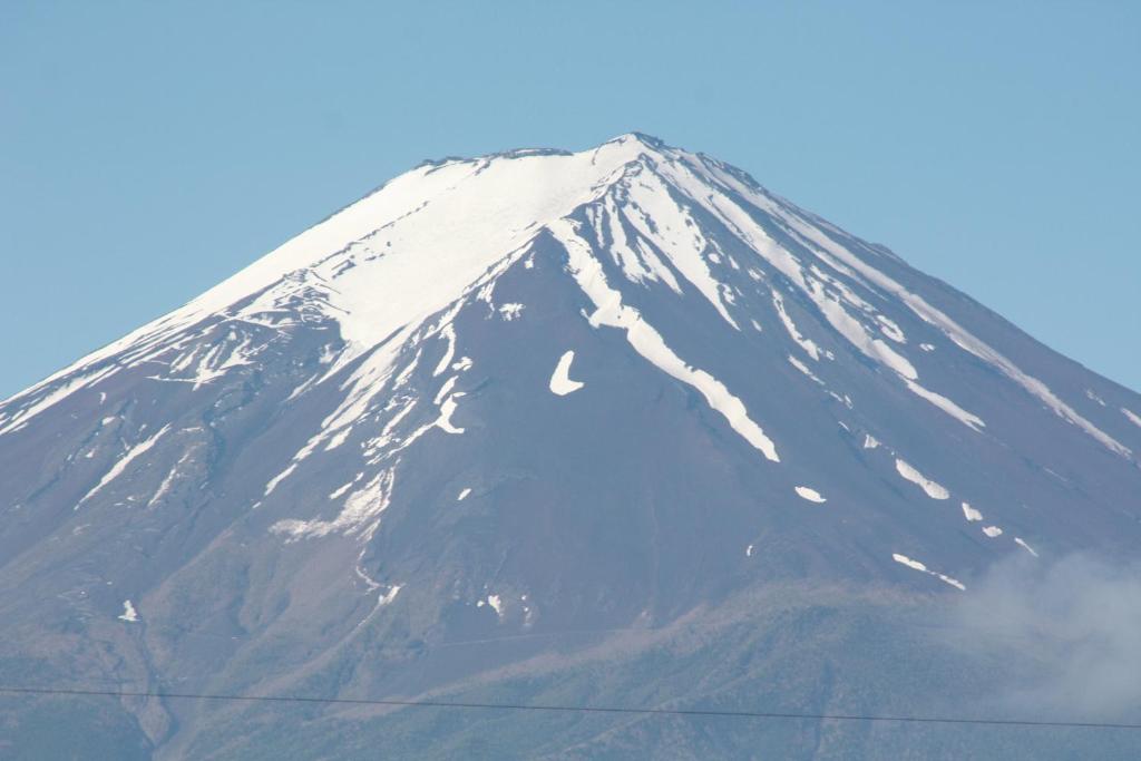 uma montanha coberta de neve no topo de uma montanha em Umeya Annex em Fujikawaguchiko