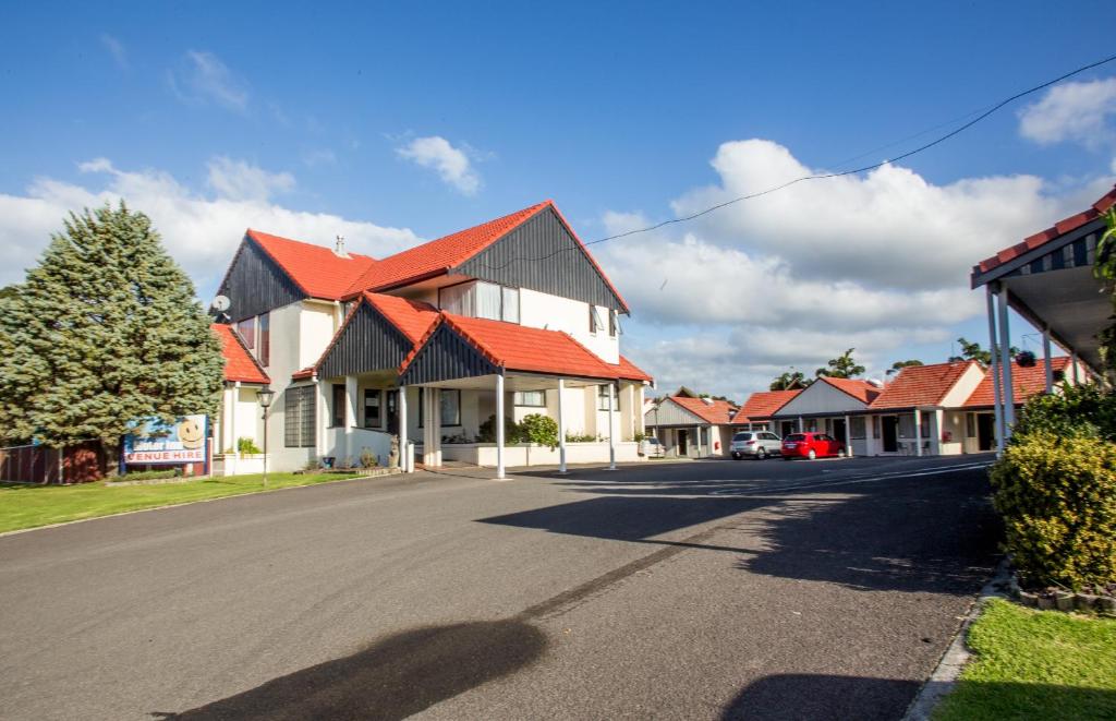 a row of houses with red roofs on a street at Bennetts Thermal Motor Inn in Tauranga