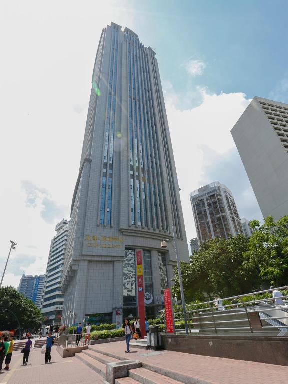 Un palazzo alto con gente che cammina davanti di Guangzhou Pengman Apartment Zhengjia Huanshi Branch a Canton