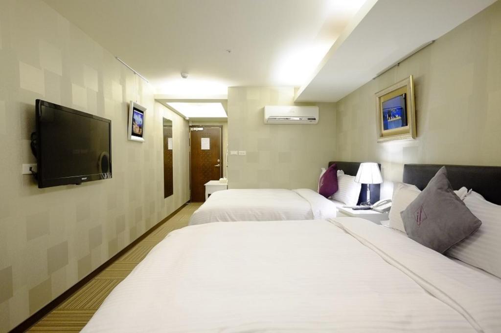 Cette chambre comprend 2 lits et une télévision à écran plat. dans l'établissement 意芙旅店 Ifinn Hotel, à Taipei