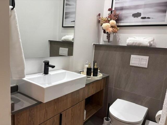 ein Badezimmer mit einem weißen Waschbecken und einer Toilette in der Unterkunft Modern Studio in Menlyn Maine in Pretoria
