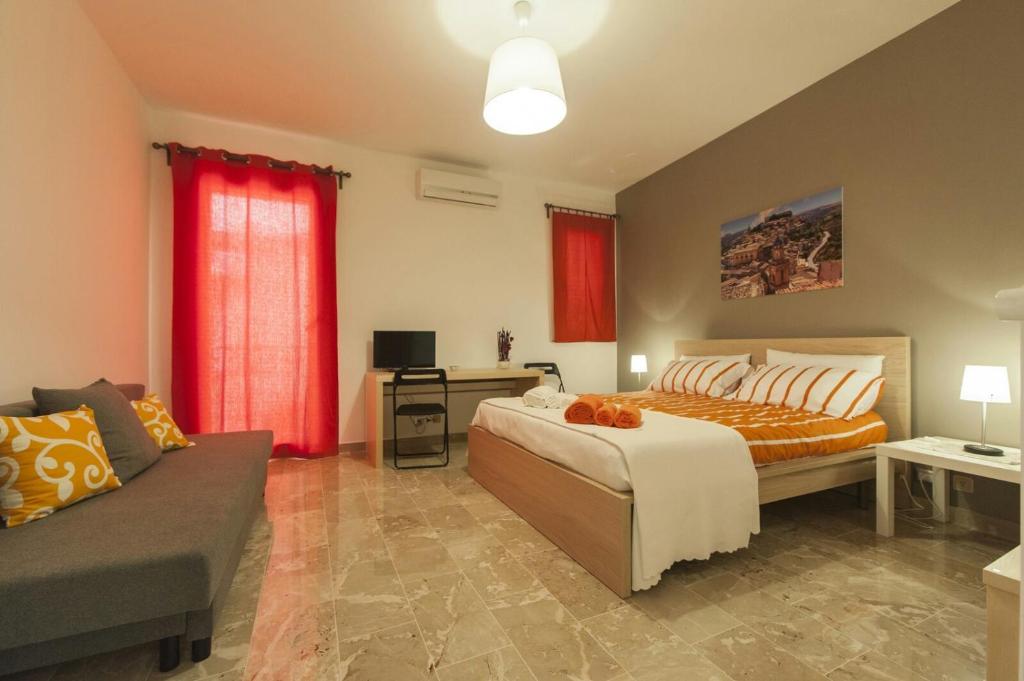 - une chambre avec un lit et un canapé dans l'établissement Ragusa Terra Priziusa, à Raguse