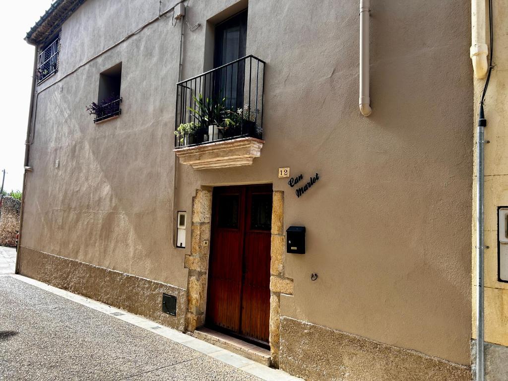 a building with a red door and a balcony at Can Marlot in Navata
