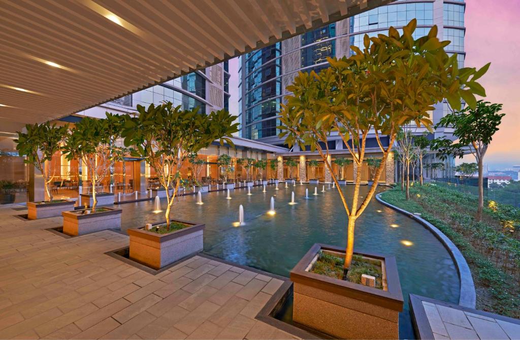 A landscaped water feature and poolside walkway beneath a covered terrace.