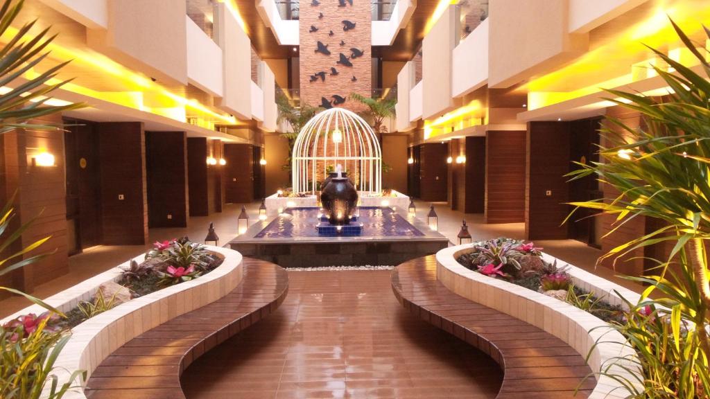 a lobby with a fountain in the middle of a building at Sweet Garden Guest House in Malang