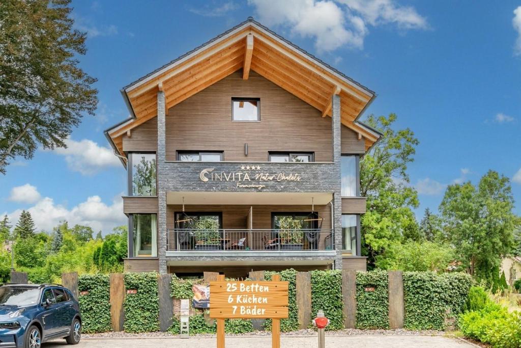 a house with a gambrel roof at INVITA Natur-Chalets - Gruppenurlaub, Events im Schwarzwald - 6 Apartments, 25 Personen in Bad Dürrheim